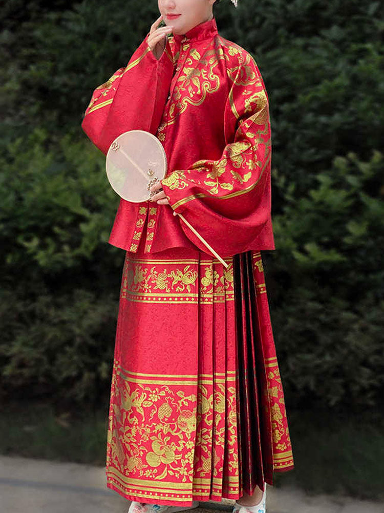 Person wearing a traditional red and gold outfit with a fan
