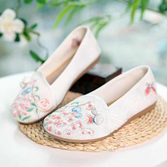 Chaussures brodées délicates de papillons et de fleurs de pêcher roses